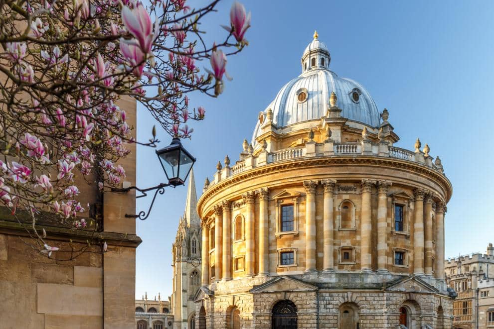 The Radcliffe Camera in Spring with pink blossoms on a tree, part of Oxford University, a host venue of Oxford Summer Schools