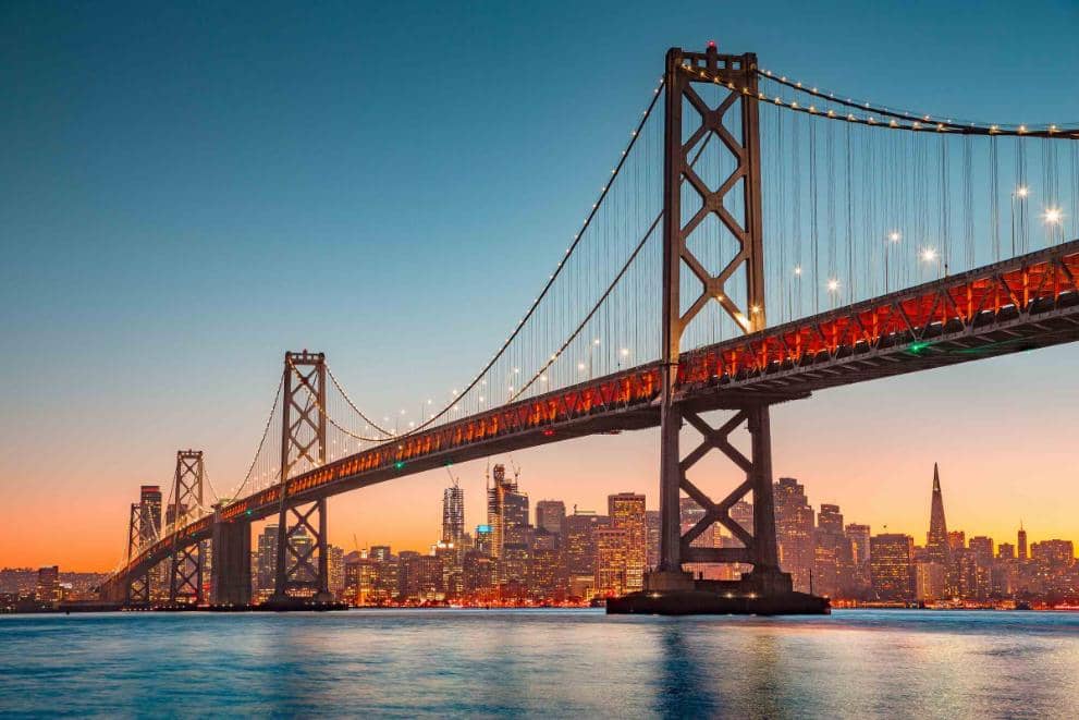 A sunset view of Oakland bay Bridge in San Francisco, a popular landmark to visit whilst attending a USA summer school